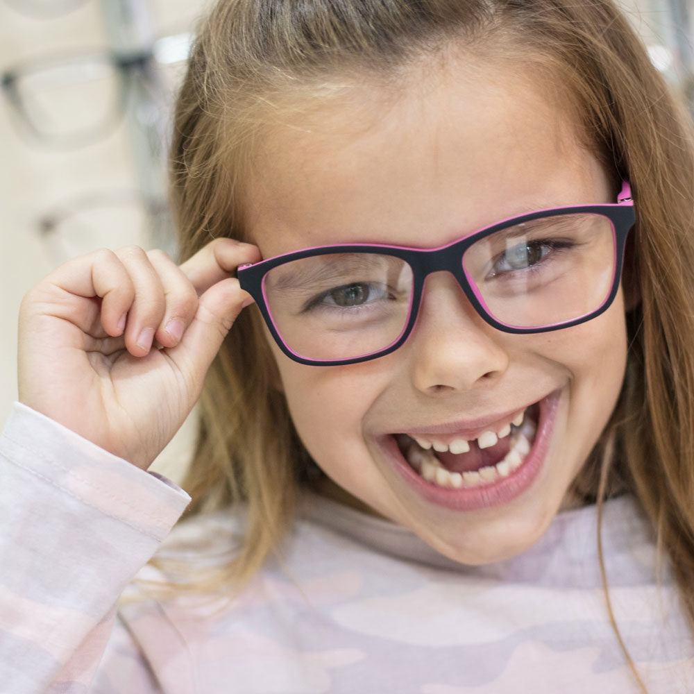 Young girl trying on a frame and smiling Young girl trying on a frame and smiling