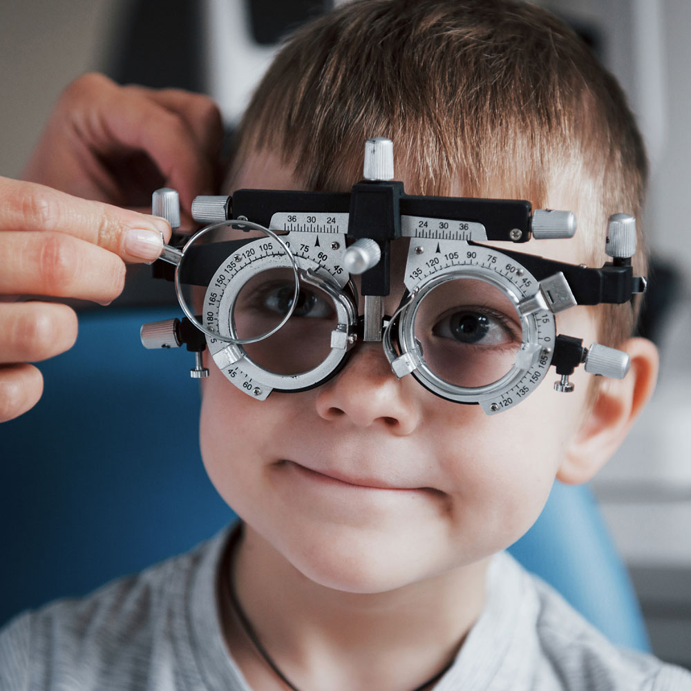 Young boy wearing a trial frame and getting vision checked Young boy wearing a trial frame and getting vision checked