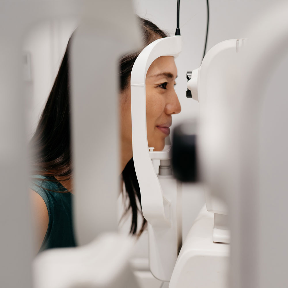 Optical machines and a woman undergoing an eye examination Optical machines and a woman undergoing an eye examination